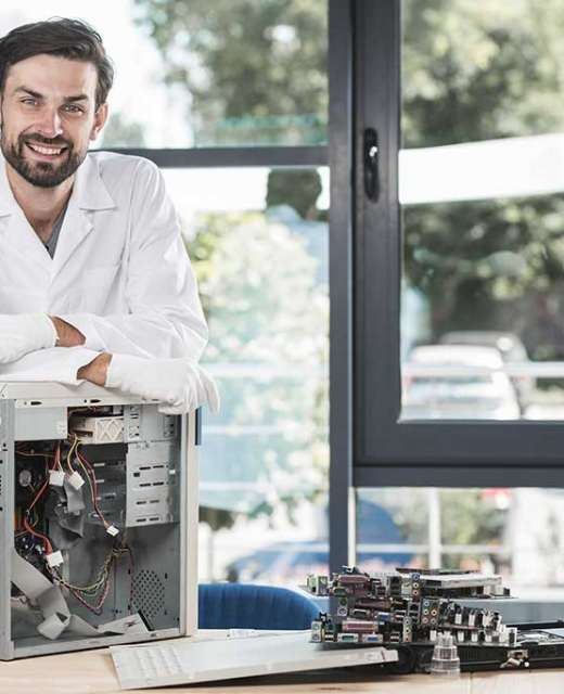 portrait-happy-male-technician-with-broken-computer