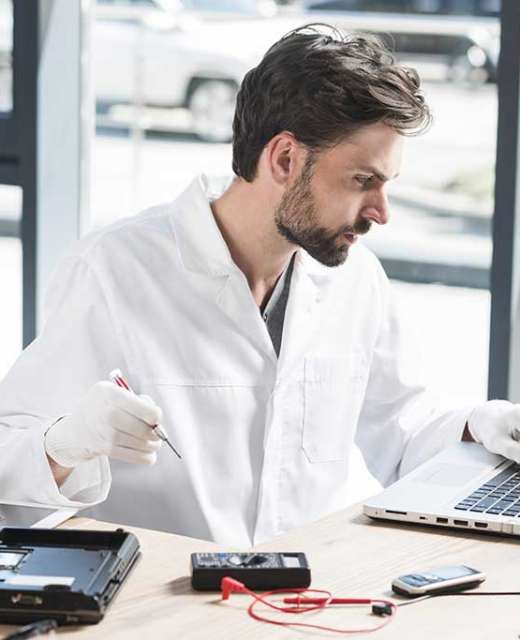 young-male-technician-using-laptop-workshop